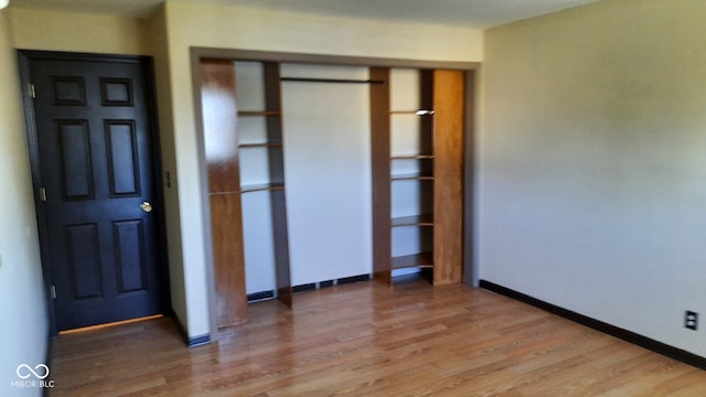 unfurnished bedroom featuring hardwood / wood-style flooring and a closet