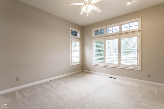 spare room featuring light carpet and ceiling fan