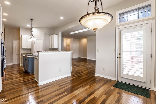 kitchen with white cabinetry, hanging light fixtures, and dark hardwood / wood-style flooring