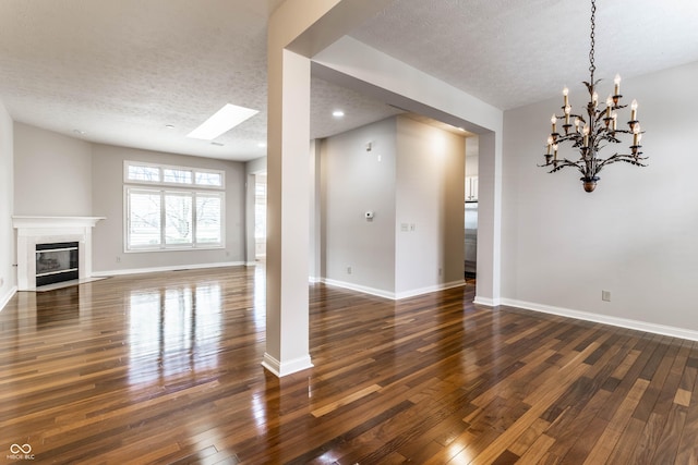 unfurnished living room with dark hardwood / wood-style floors, a tiled fireplace, and a textured ceiling