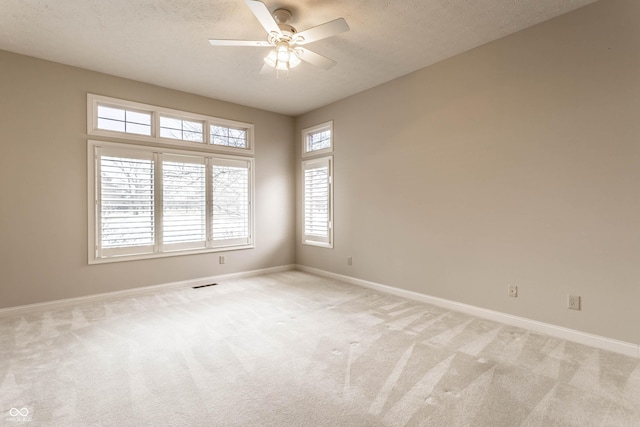 carpeted empty room with ceiling fan and a textured ceiling