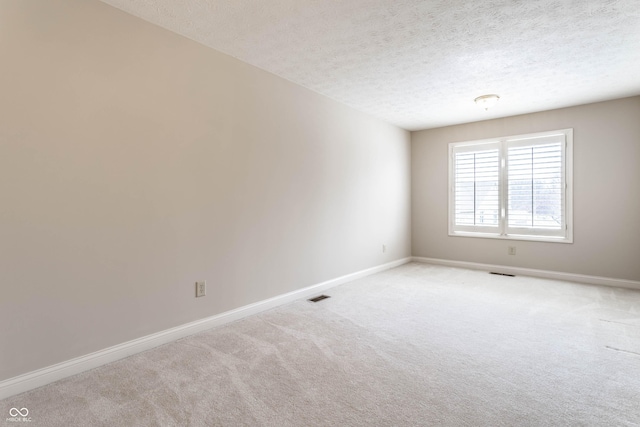 carpeted spare room featuring a textured ceiling