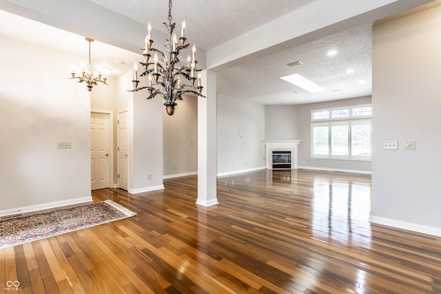 unfurnished living room featuring dark wood-type flooring and a textured ceiling