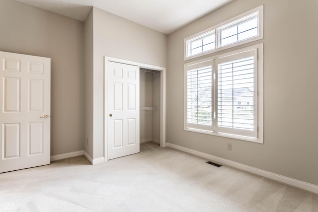 unfurnished bedroom with a closet and light carpet