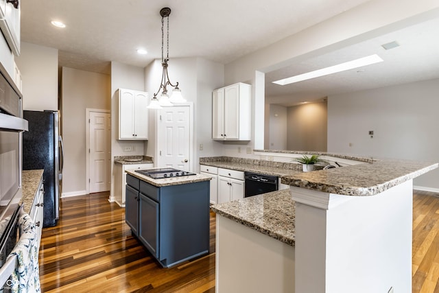 kitchen with hanging light fixtures, white cabinetry, a kitchen island, and black appliances