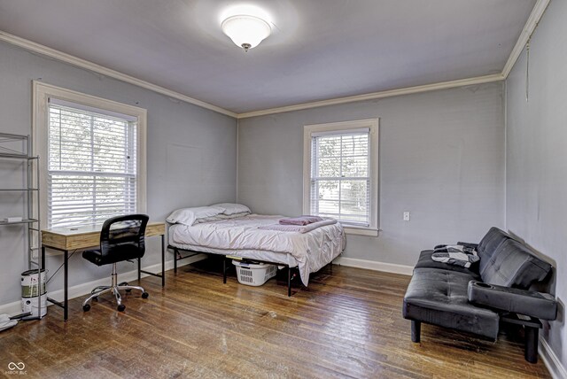 bedroom with ornamental molding, baseboards, and wood finished floors