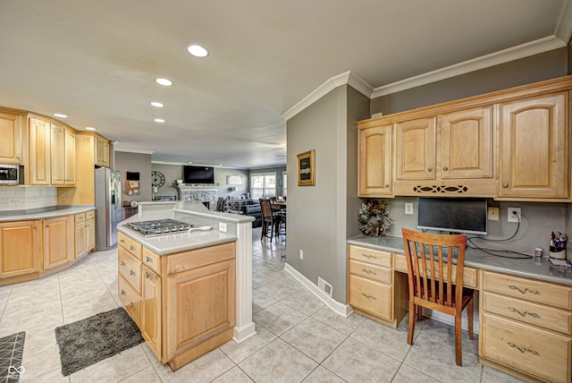 kitchen featuring stainless steel appliances, open floor plan, built in study area, light brown cabinetry, and crown molding