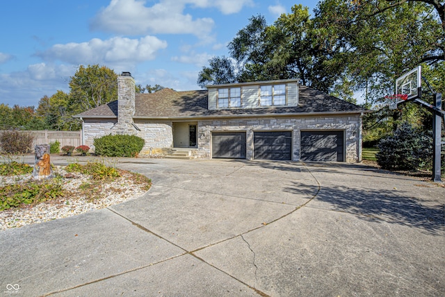 view of front facade with a chimney, fence, a garage, stone siding, and driveway