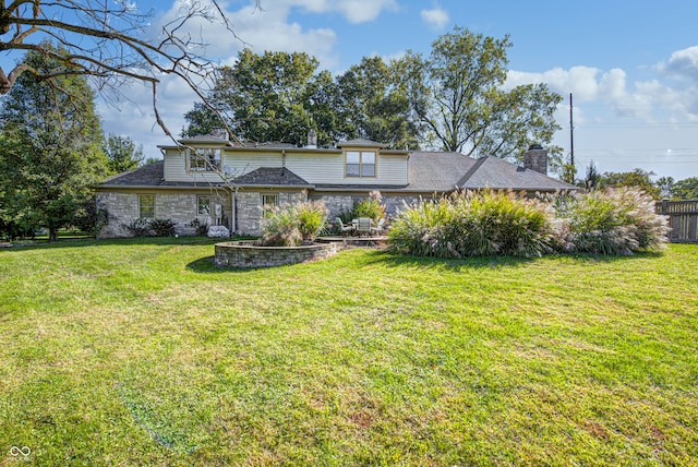 view of front of house featuring a front yard, stone siding, and a chimney