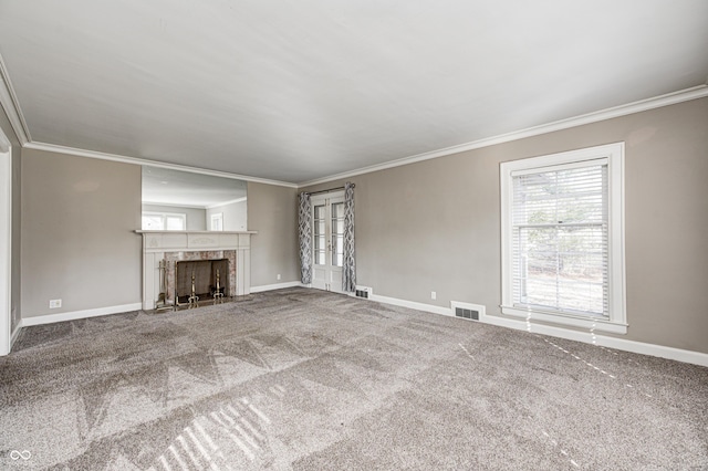 unfurnished living room with carpet, a premium fireplace, ornamental molding, and baseboards