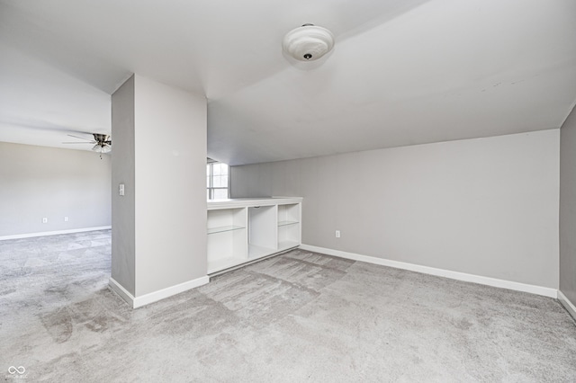 additional living space with lofted ceiling, carpet, a ceiling fan, and baseboards