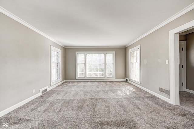 carpeted empty room featuring baseboards, visible vents, and crown molding