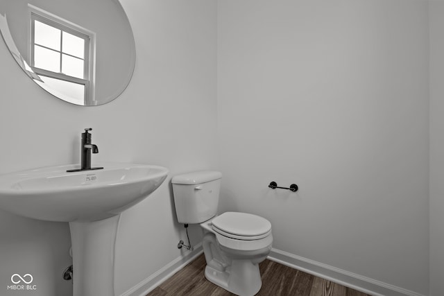 bathroom featuring hardwood / wood-style flooring, toilet, and sink