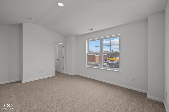 carpeted spare room featuring lofted ceiling