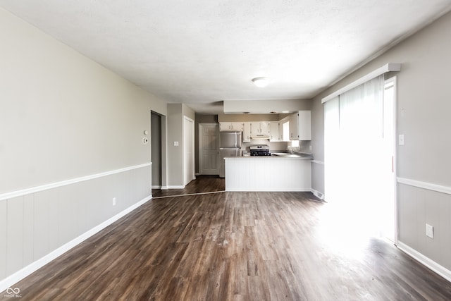 kitchen featuring dark hardwood / wood-style floors, stainless steel refrigerator, a textured ceiling, and white cabinetry