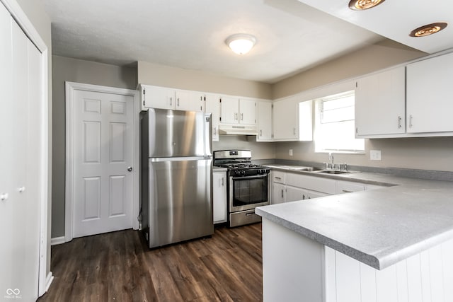 kitchen featuring stainless steel appliances, white cabinets, dark wood-type flooring, sink, and kitchen peninsula