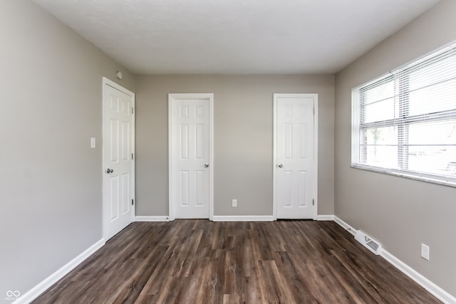 unfurnished bedroom featuring dark hardwood / wood-style flooring