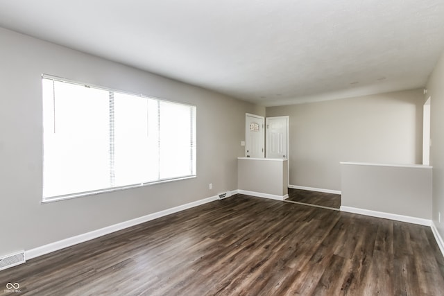 unfurnished room with dark wood-type flooring