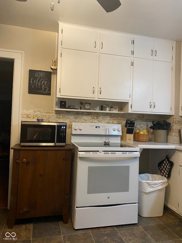 kitchen featuring white cabinets, white electric range oven, and backsplash