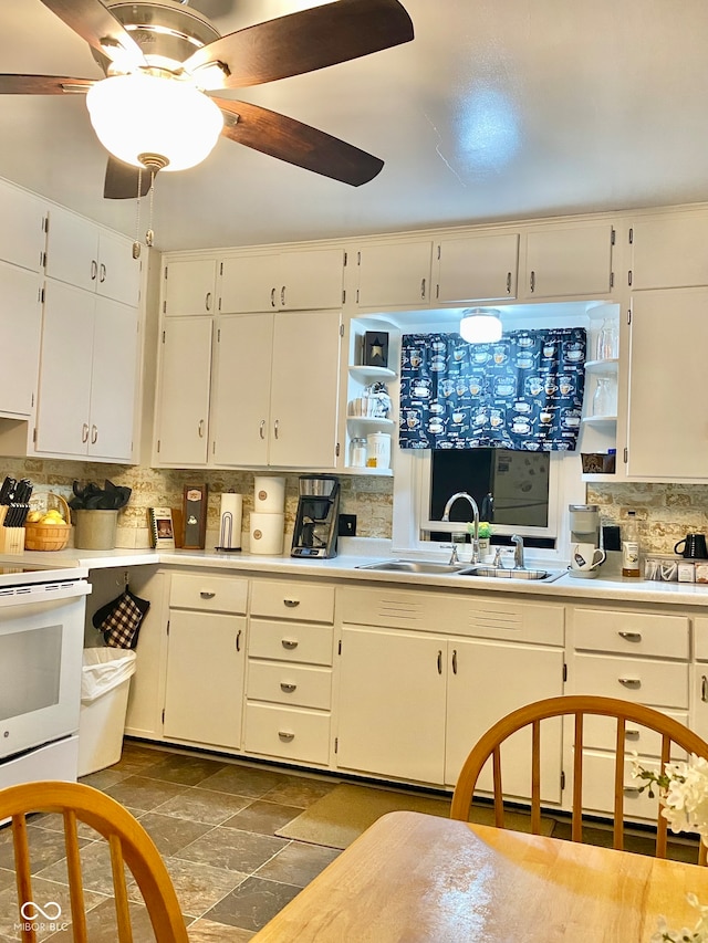 kitchen with sink, white cabinetry, white range, and tasteful backsplash