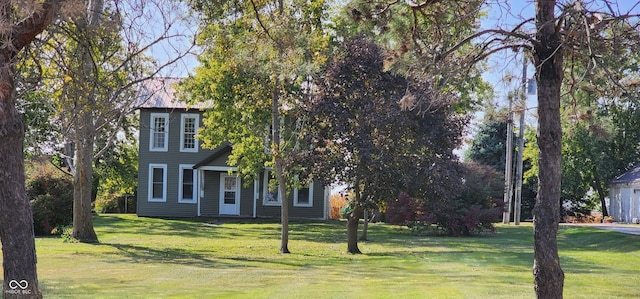 view of property hidden behind natural elements with a front yard