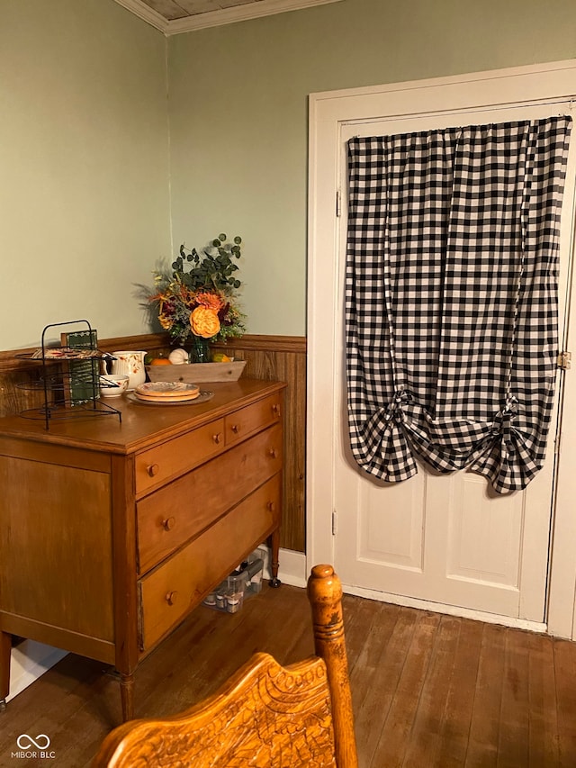 bedroom featuring dark hardwood / wood-style floors, wood walls, and crown molding