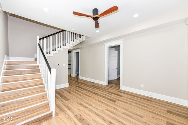 staircase featuring hardwood / wood-style flooring and ceiling fan