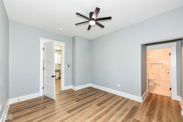 unfurnished bedroom with ceiling fan, hardwood / wood-style floors, and connected bathroom