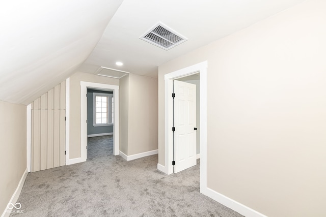 additional living space featuring lofted ceiling and light carpet