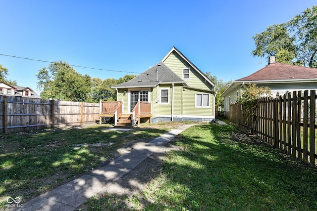 rear view of property featuring a lawn and a deck