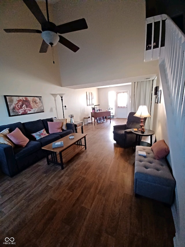 living room featuring dark hardwood / wood-style floors, ceiling fan, and a high ceiling