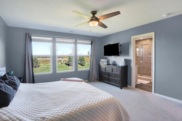 bedroom featuring connected bathroom, light carpet, and ceiling fan