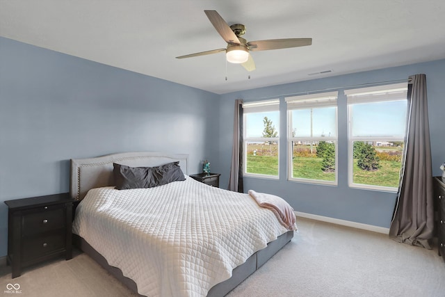 bedroom featuring light colored carpet, multiple windows, and ceiling fan