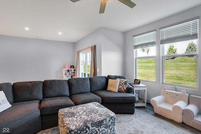 living room with light wood-type flooring, ceiling fan, and a healthy amount of sunlight