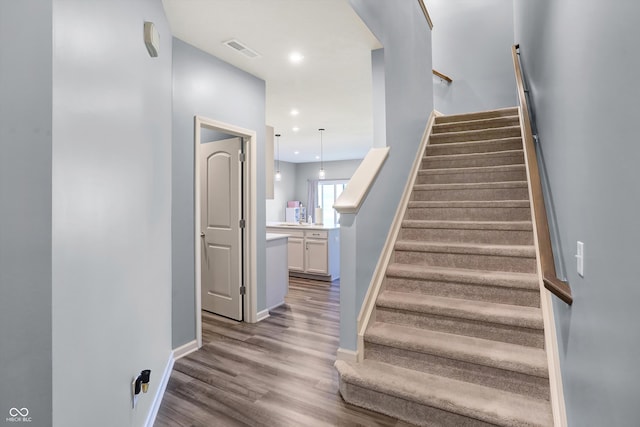 stairway with sink and hardwood / wood-style floors