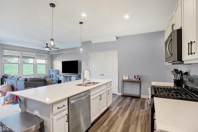 kitchen with a center island with sink, stainless steel appliances, sink, white cabinets, and ceiling fan