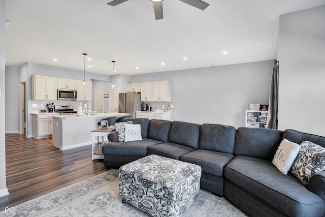 living room featuring wood-type flooring and ceiling fan