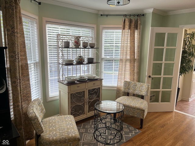 living area featuring crown molding and hardwood / wood-style flooring