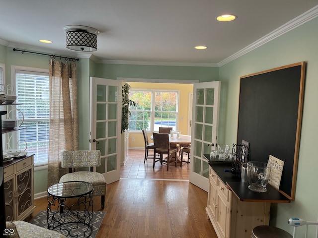 interior space with french doors, light hardwood / wood-style flooring, crown molding, and plenty of natural light