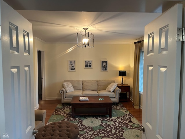 living room featuring an inviting chandelier, crown molding, and dark hardwood / wood-style floors