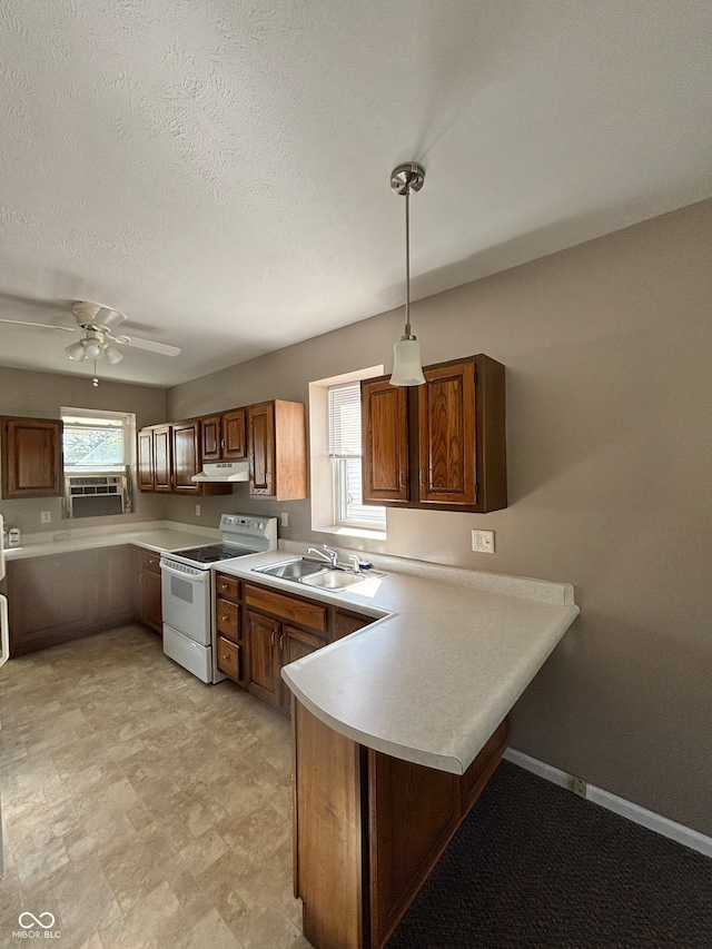 kitchen featuring ceiling fan, range, decorative light fixtures, sink, and kitchen peninsula