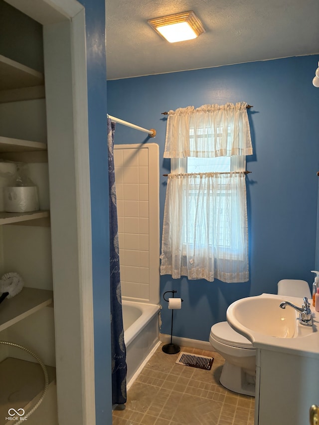 full bathroom featuring vanity, shower / bath combination with curtain, tile patterned flooring, toilet, and a textured ceiling