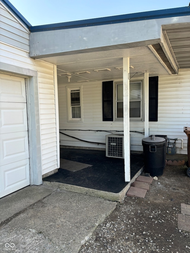 property entrance with a garage and cooling unit