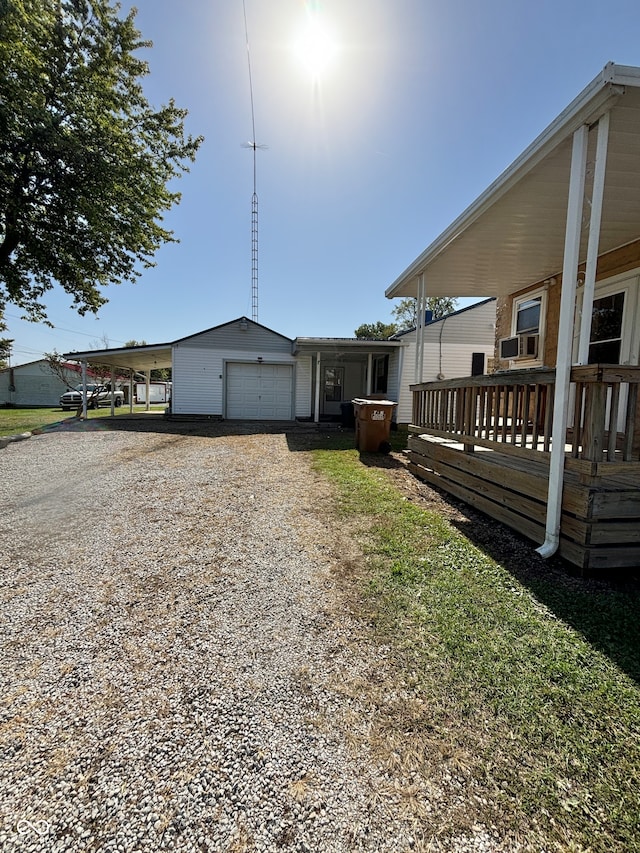 view of side of home with a garage, a deck, and an outbuilding