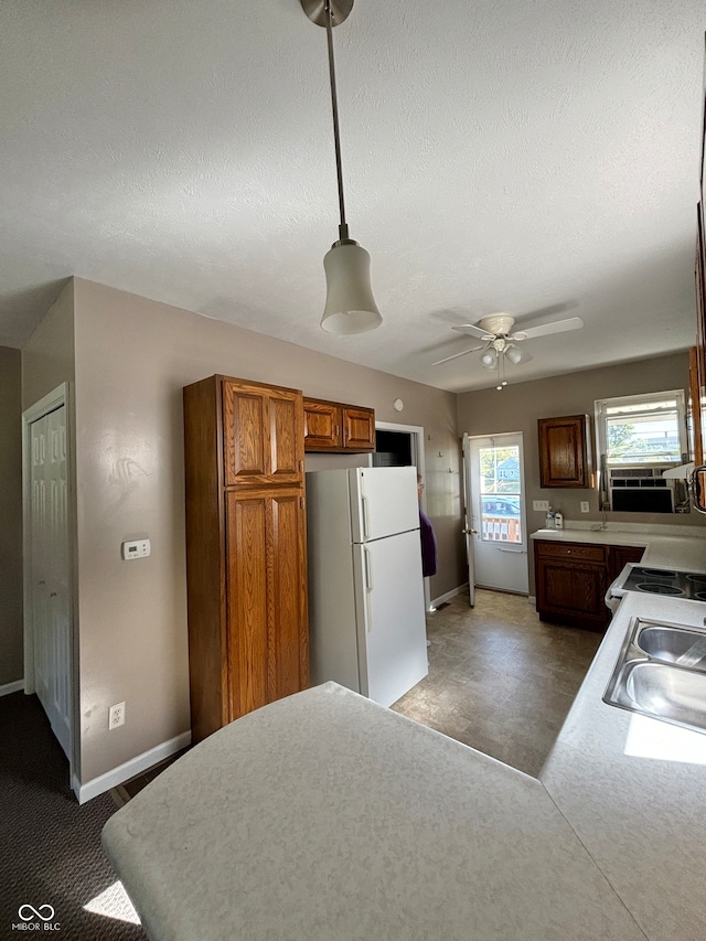 kitchen with ceiling fan, pendant lighting, sink, a textured ceiling, and white fridge