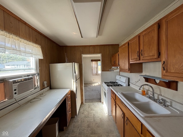 kitchen featuring wooden walls, cooling unit, white appliances, and sink