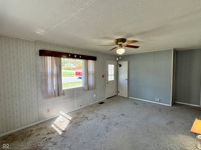 empty room with carpet, a textured ceiling, and ceiling fan