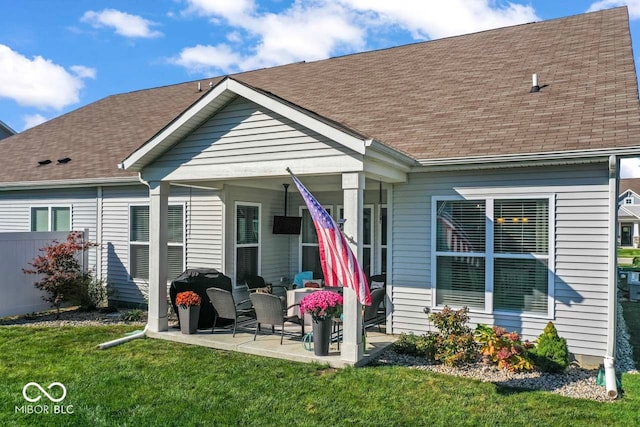 rear view of house featuring a yard and a patio