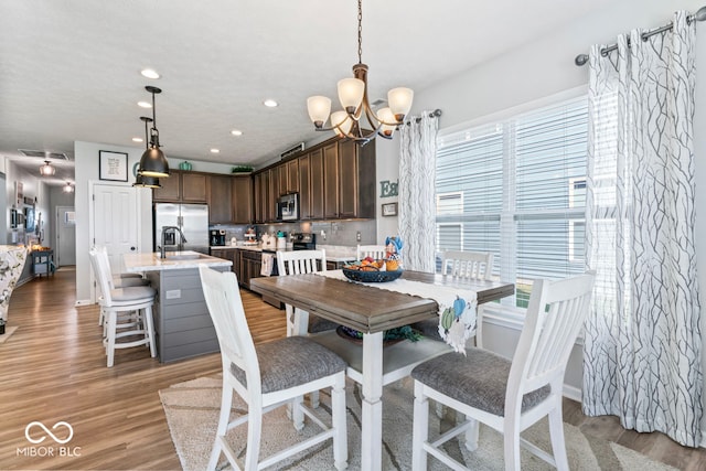 dining room featuring plenty of natural light, light hardwood / wood-style floors, and a chandelier