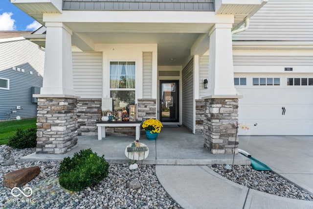 view of exterior entry with a garage and covered porch